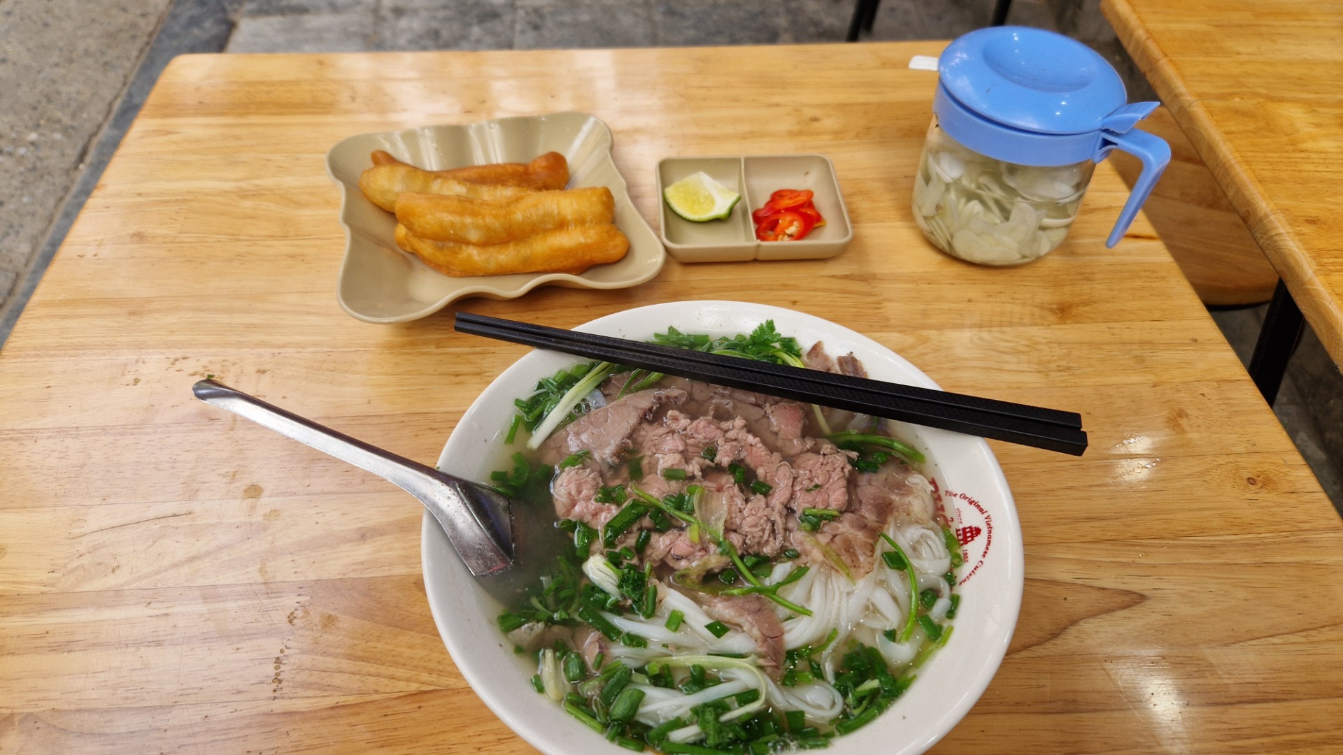 Snad nejprofláklejší vietnamský pokrm: hovězí polévka. Papričky podávané odděleně.